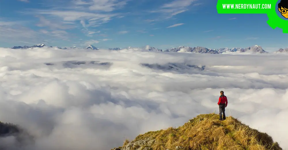 Man Standing on Mountain Against Sky after Hiking
