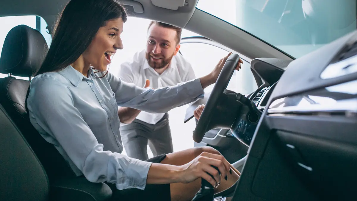 Car salesman showing a car to woman