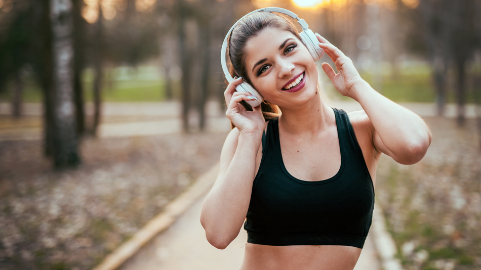 woman on a long jogging walk while listening music using a wireless headphone